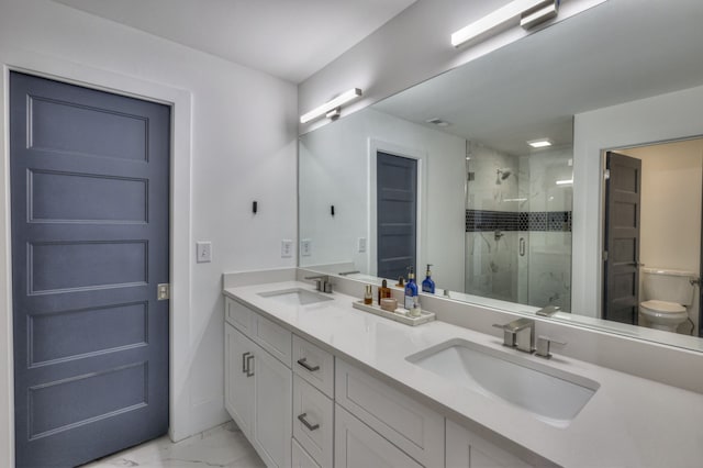 bathroom featuring vanity, toilet, and a shower with door