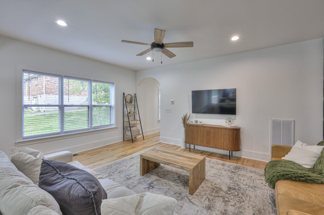 living room with ceiling fan and light hardwood / wood-style flooring