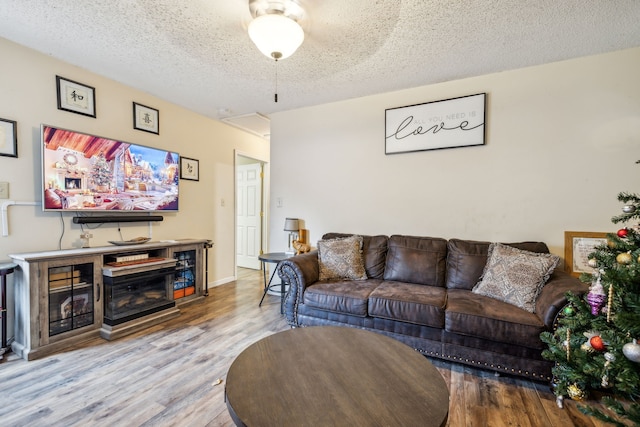 living room with a textured ceiling and light wood-type flooring