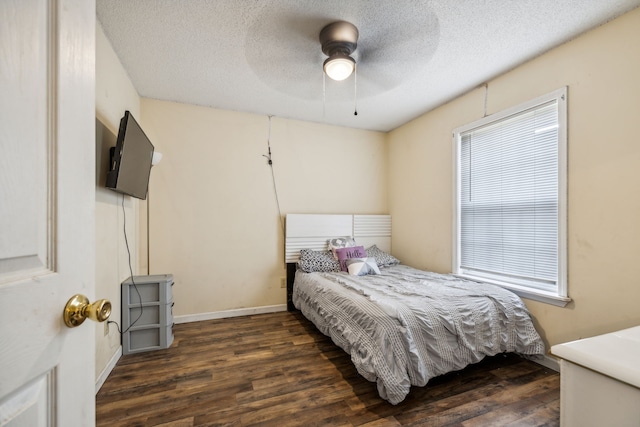 bedroom with a textured ceiling, ceiling fan, and dark wood-type flooring