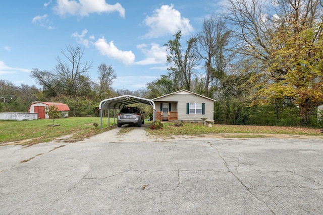 view of front facade featuring a carport, a storage shed, covered porch, and a front yard