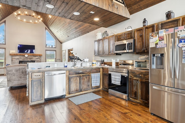 kitchen featuring hanging light fixtures, wooden ceiling, dark hardwood / wood-style flooring, high vaulted ceiling, and appliances with stainless steel finishes