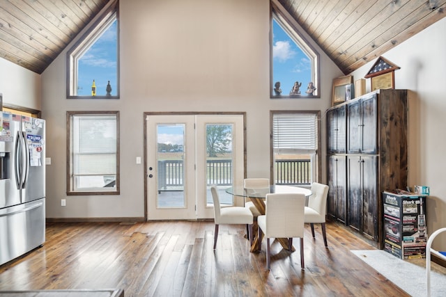 dining room featuring hardwood / wood-style floors, high vaulted ceiling, and wood ceiling