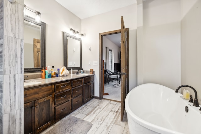 bathroom with hardwood / wood-style floors, vanity, and a tub to relax in