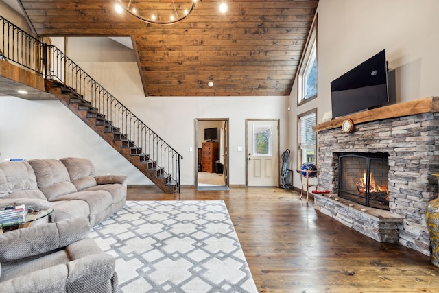 living room with hardwood / wood-style flooring, high vaulted ceiling, a stone fireplace, and wood ceiling