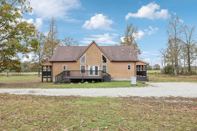 back of house with a deck and a lawn