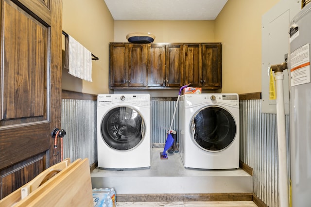 clothes washing area with cabinets and washer and dryer