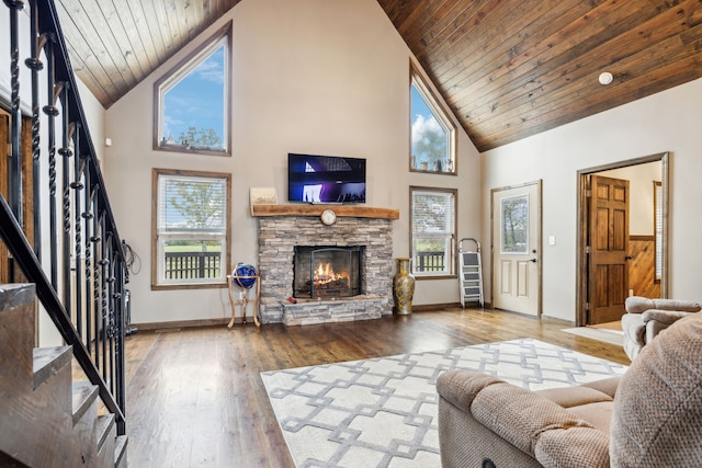 living room with a fireplace, hardwood / wood-style floors, high vaulted ceiling, and wooden ceiling