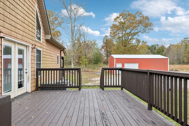 wooden deck with a garage and an outbuilding