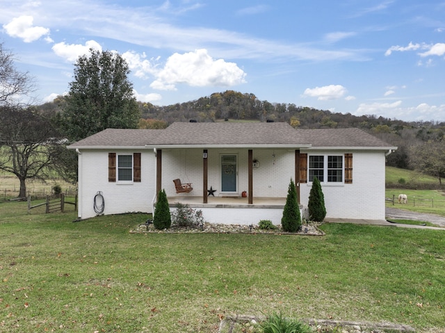 ranch-style house featuring a porch and a front lawn