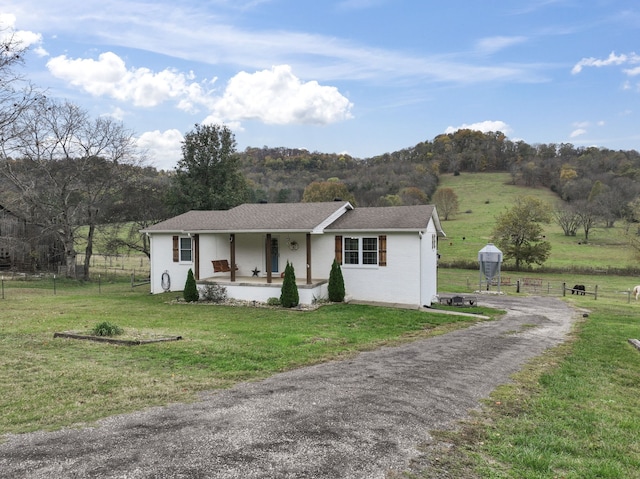 single story home featuring a front yard, a porch, and a rural view