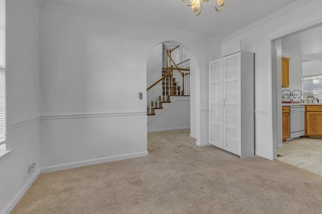 empty room with light carpet, a notable chandelier, and ornamental molding