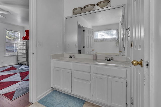 bathroom with wood-type flooring, vanity, and ceiling fan