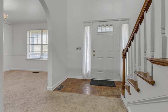 foyer entrance featuring parquet flooring and ornamental molding