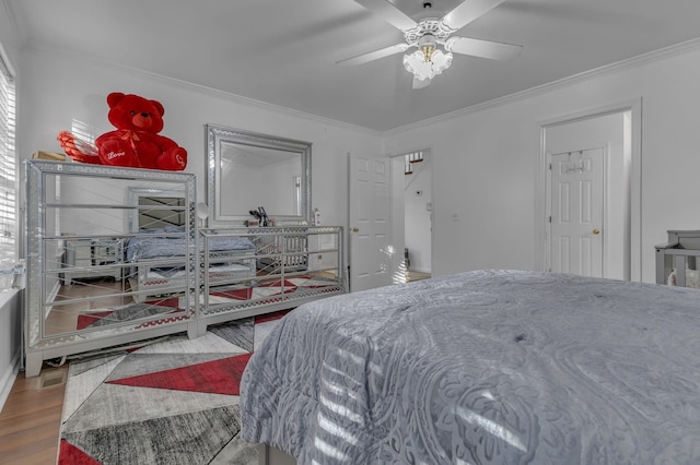 bedroom with hardwood / wood-style flooring, ceiling fan, and ornamental molding