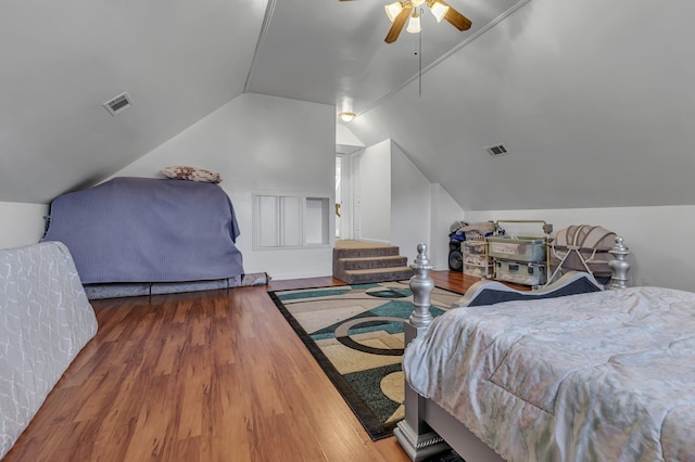 bedroom with dark hardwood / wood-style floors, vaulted ceiling, and ceiling fan