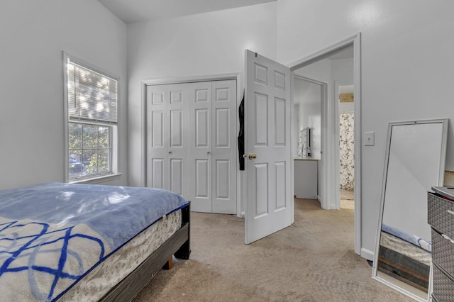 bedroom featuring light colored carpet and a closet