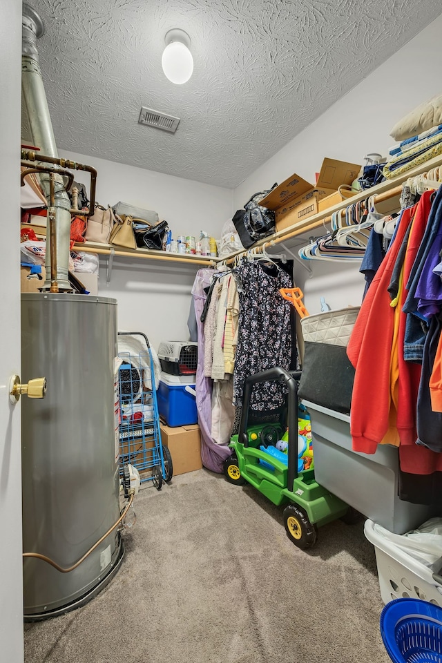 walk in closet with carpet flooring and gas water heater