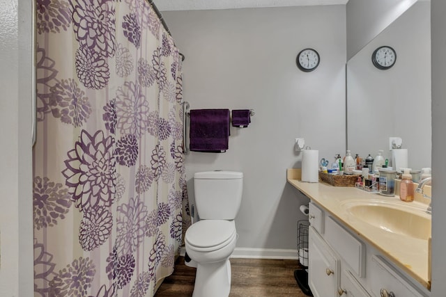 bathroom with wood-type flooring, vanity, and toilet