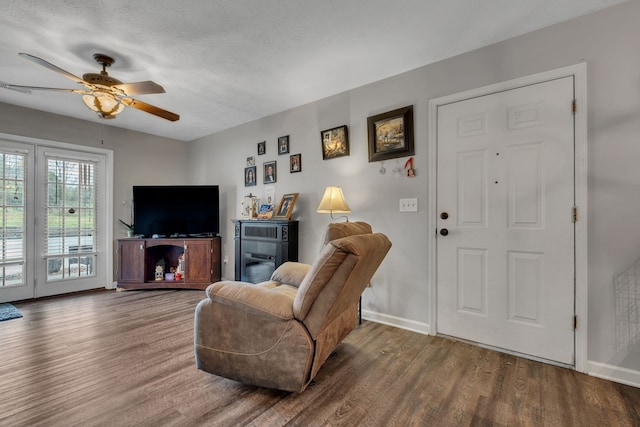 living room with hardwood / wood-style floors, ceiling fan, and a textured ceiling