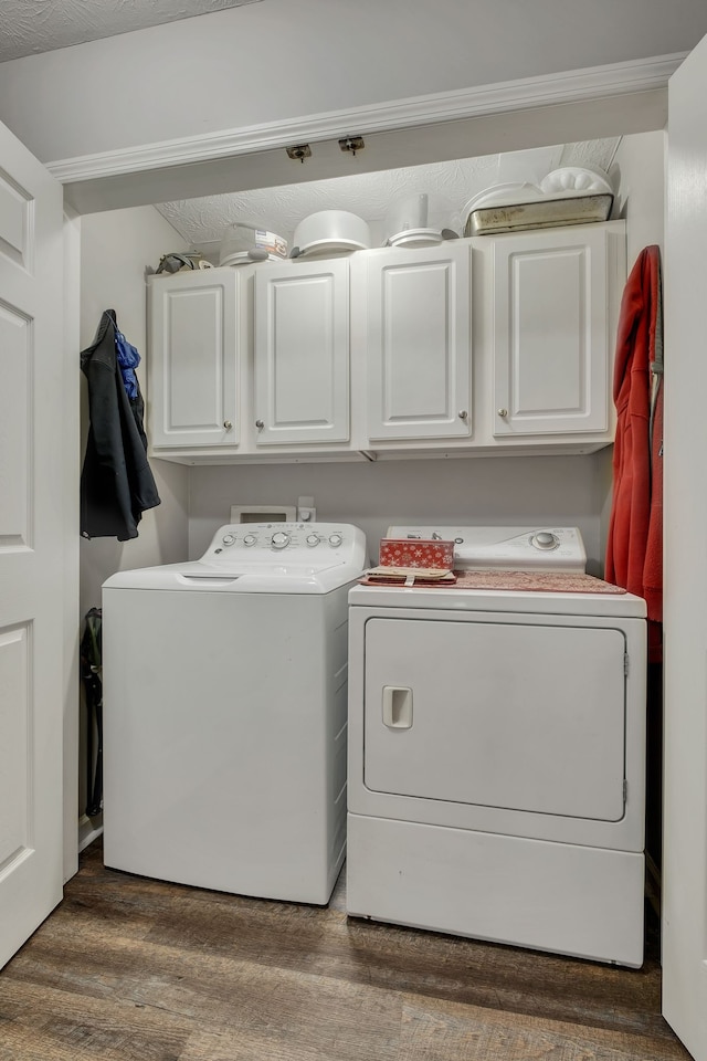 laundry room with washer and dryer, dark wood-type flooring, cabinets, and a textured ceiling