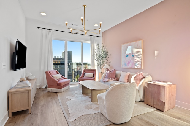 living room with light wood-type flooring and an inviting chandelier