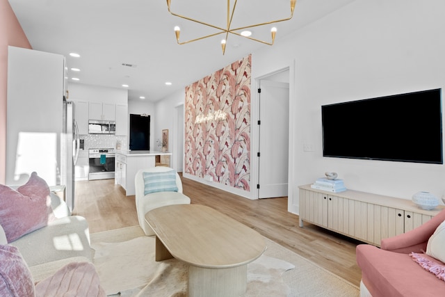 living room with light hardwood / wood-style flooring and a notable chandelier