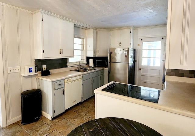 kitchen featuring sink, tasteful backsplash, white cabinetry, and black appliances