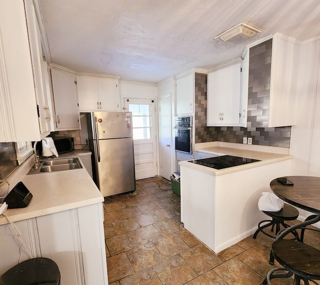 kitchen featuring backsplash, black appliances, white cabinets, sink, and ornamental molding