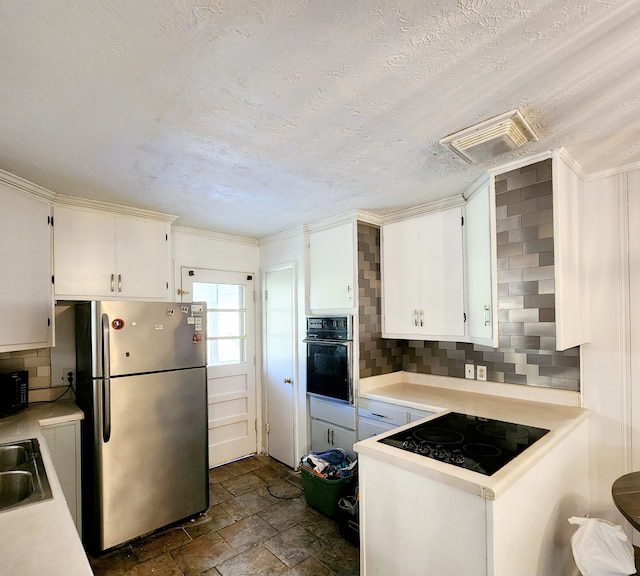 kitchen with tasteful backsplash, white cabinetry, sink, and black appliances