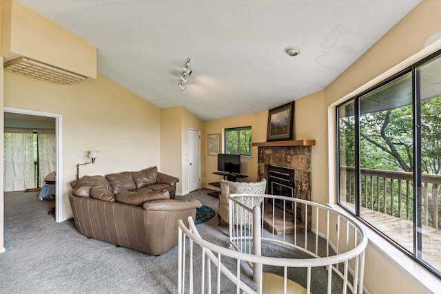 carpeted living room featuring a fireplace, rail lighting, and vaulted ceiling