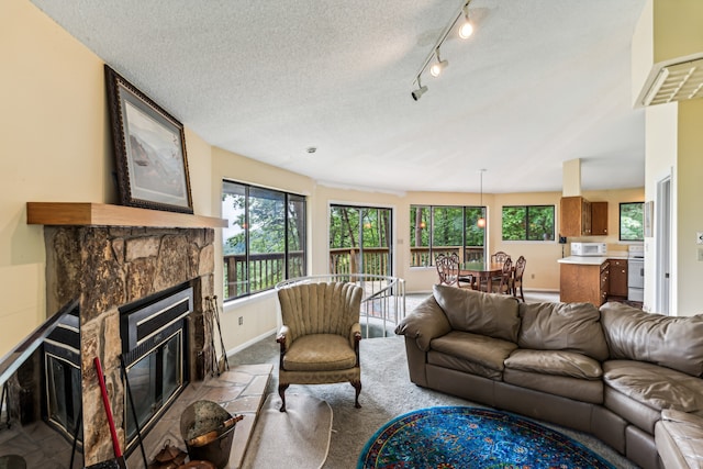 carpeted living room with a stone fireplace and a textured ceiling