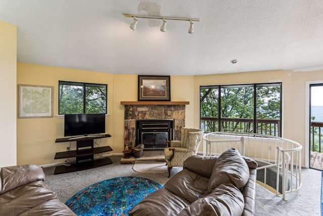 living room featuring carpet flooring, a fireplace, plenty of natural light, and a textured ceiling