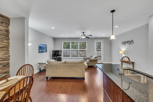 living room with ceiling fan, dark wood-type flooring, and sink