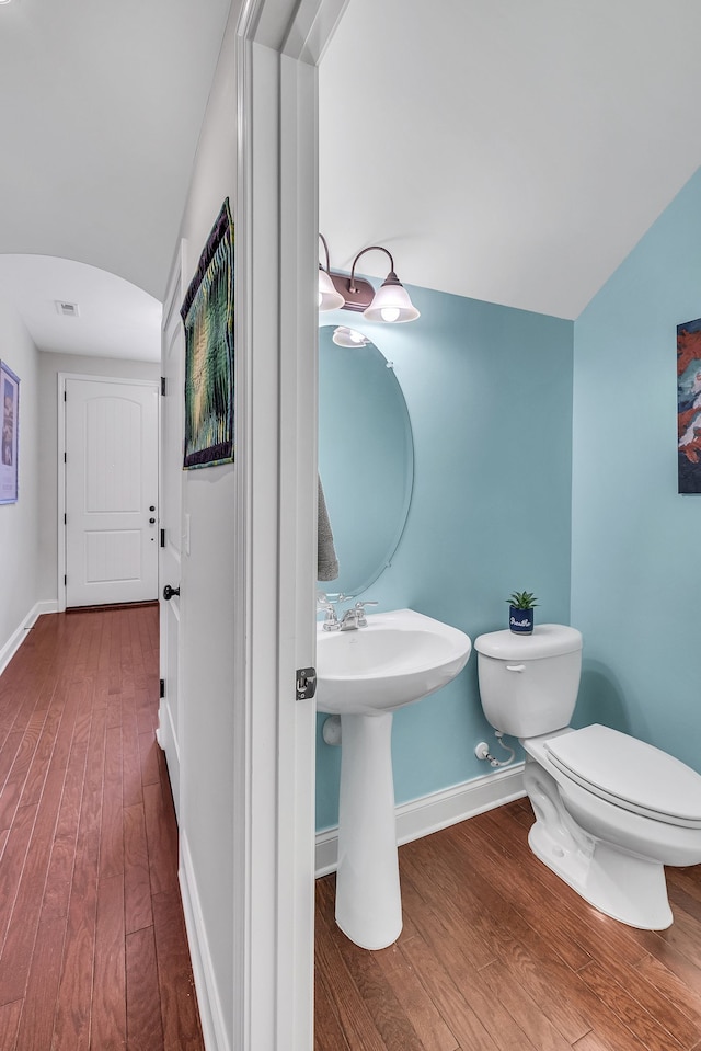 bathroom with hardwood / wood-style flooring and toilet