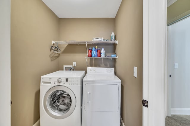 clothes washing area with washing machine and dryer