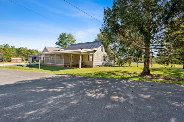 view of front facade with a front lawn and a sunroom