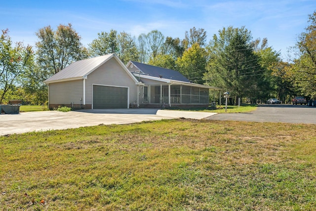 ranch-style house featuring a garage, a front yard, and a sunroom