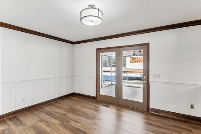 empty room featuring crown molding, a textured ceiling, and dark hardwood / wood-style floors