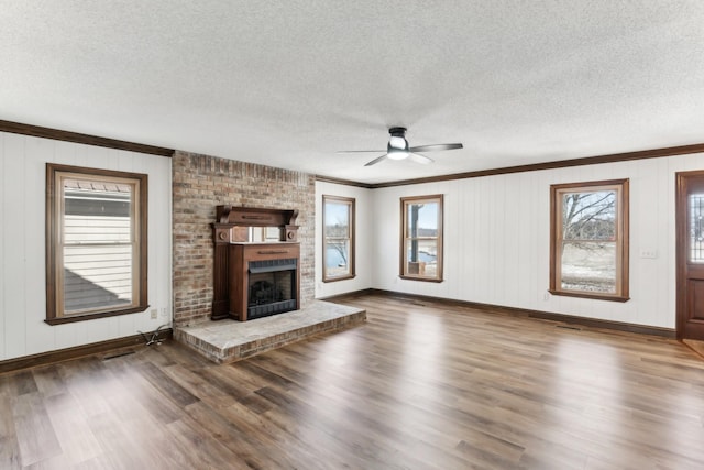 unfurnished living room featuring a brick fireplace, a textured ceiling, and dark hardwood / wood-style flooring