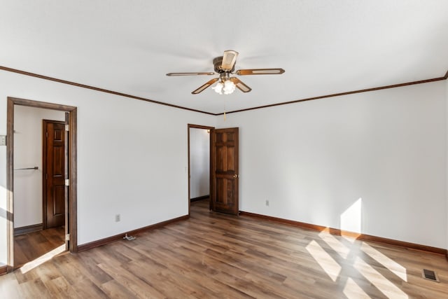 empty room with ceiling fan, wood-type flooring, and ornamental molding