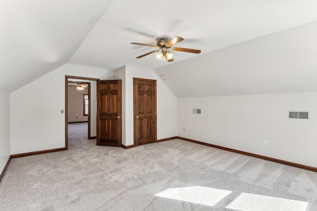 additional living space featuring light colored carpet, vaulted ceiling, and ceiling fan