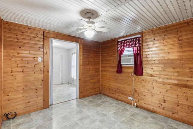 unfurnished room featuring ceiling fan, cooling unit, and wood walls