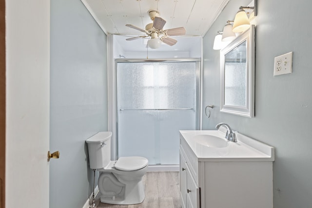 bathroom featuring hardwood / wood-style floors, vanity, toilet, and a shower with door