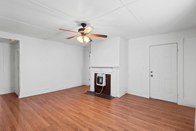 unfurnished living room with heating unit, ceiling fan, and hardwood / wood-style flooring