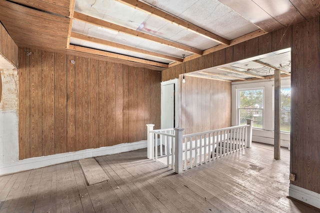 spare room featuring hardwood / wood-style flooring, wood walls, wood ceiling, and beam ceiling