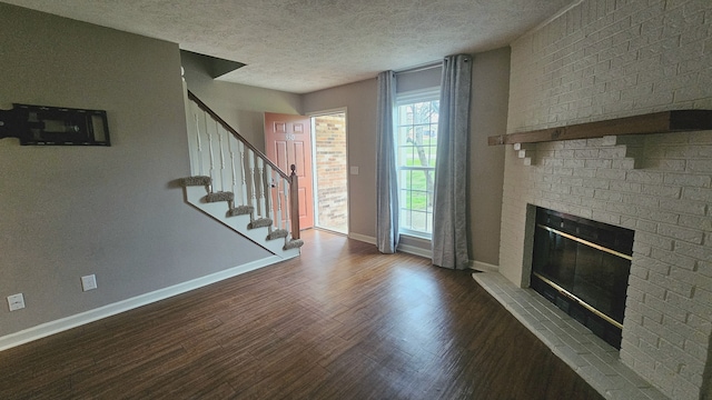 unfurnished living room with a textured ceiling, a fireplace, and dark wood-type flooring