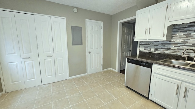 kitchen with tasteful backsplash, sink, light tile patterned floors, dishwasher, and white cabinetry