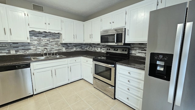 kitchen featuring stainless steel appliances, white cabinetry, and sink