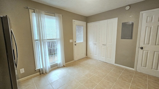 tiled foyer featuring a healthy amount of sunlight and a textured ceiling